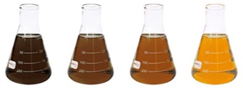 a photo of four identical clear glass flasks showing increasing clarity of fuels. The flask on the far left has dark brown opaque fuel, the next to the right is slightly lighter brown and slightly clearer, the next is even lighter and clearer and the last has fully clear amber liquid.